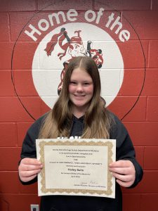 student with long flowy hair holds certificate 