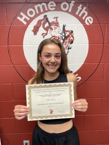 student smiles holding certificate