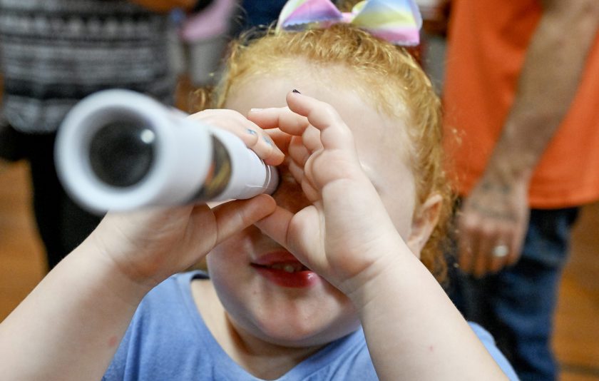 student looks through microscope