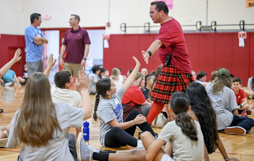 teacher gives group of students high fives