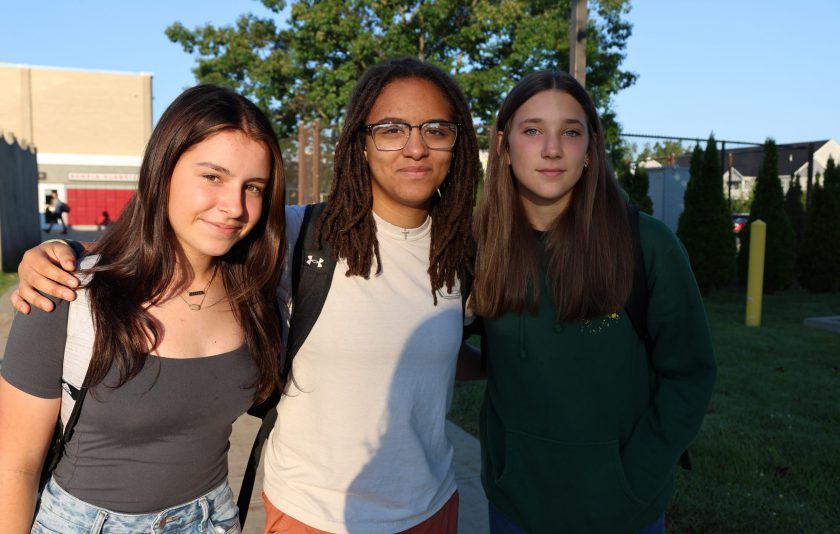 three students standing outside