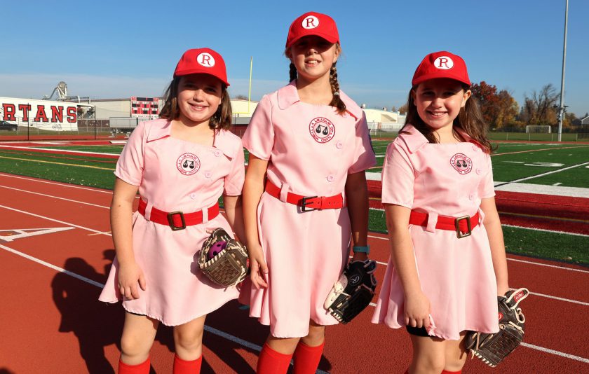 three students wearing pink baseball uniforms from the move A League of Their Own