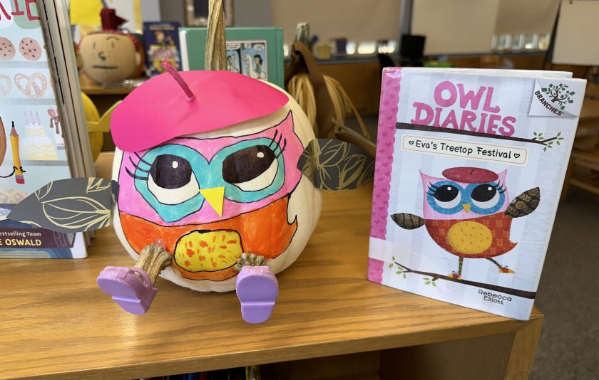 a pumpkin decorated like a pink owl with the book Owl Diaries next to it