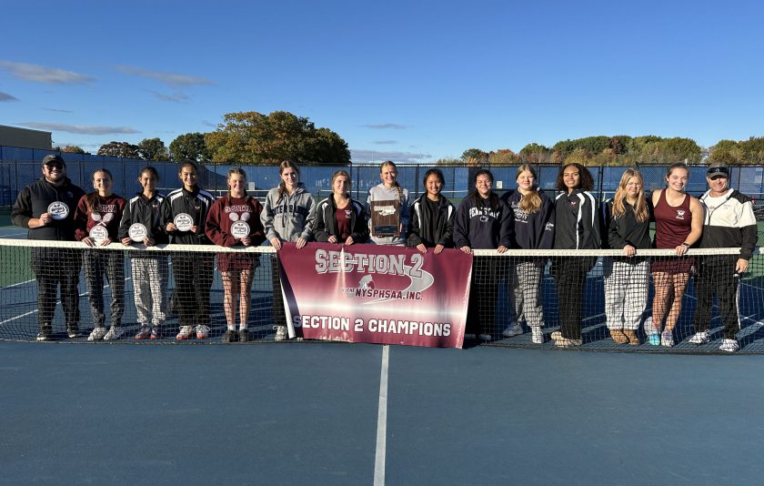 tennis players standing behind the net with a section 2 championship sign in front of them