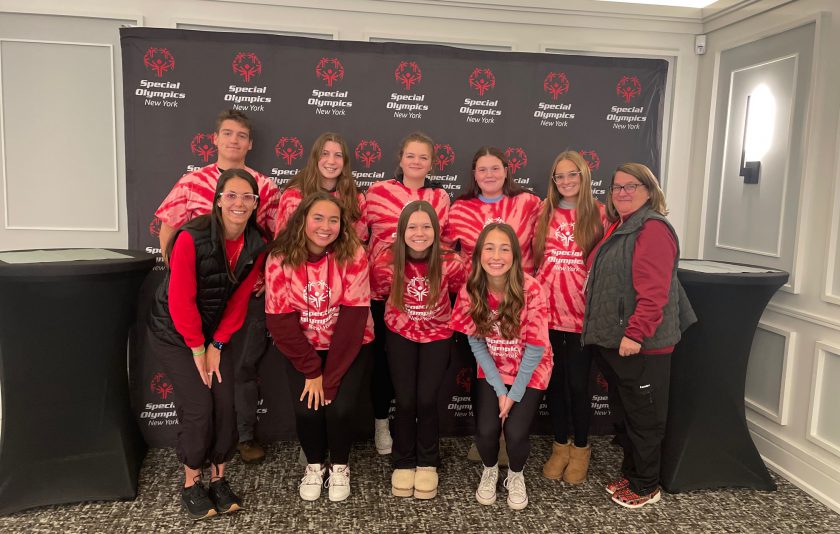 eight students wearing red and pink tie dyes for special olympics and two adult advisers