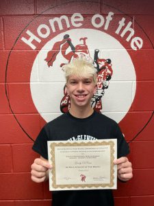 student with short platnum hair holding certificate