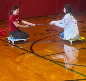 two students holding a rope on spinners