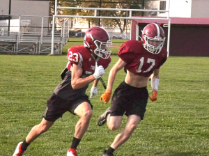 two football players running at practice