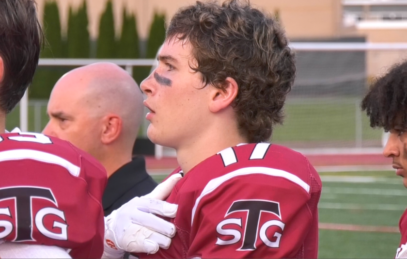 football player with hand on heart singing National Anthem