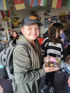 student holding a plate of sweet treats