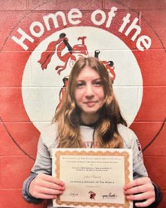 student with long wavy hair holds certificate