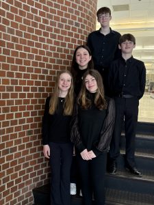 five students standing in a tier on steps