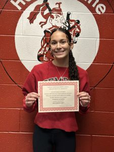 student smiles while holding up Athlete of the Month Certificate