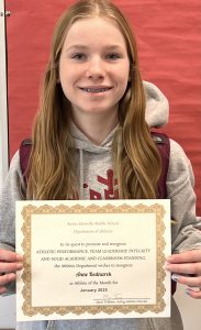 student smiling holding her certificate of achievement