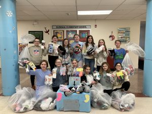 students gather together with socks in their hands and bags of socks all around them