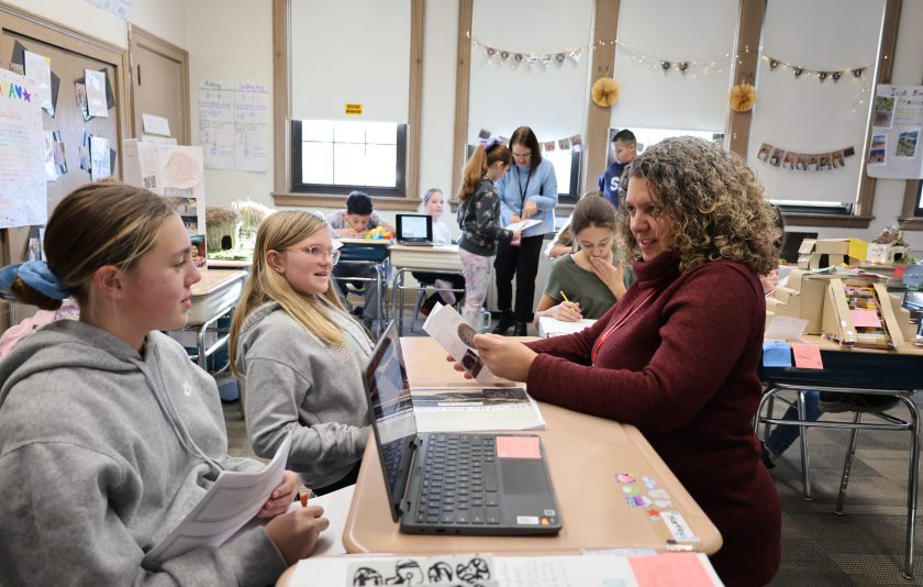 two students look up at principal who is asking about their project