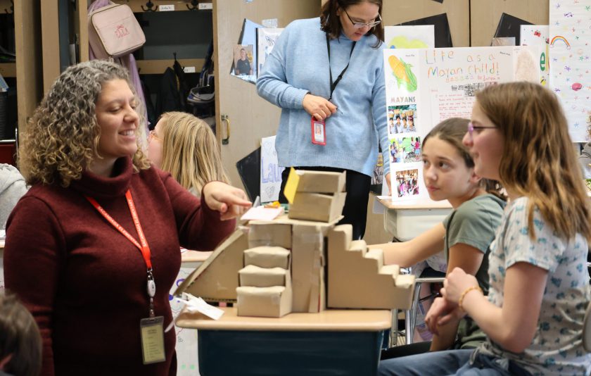 principal looking at pyramid and students happy