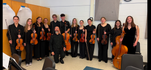 High School orchestra performers with guest conductor all dressed in black