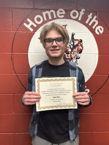 student smiles holding certificate of achievement