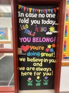 a colorful decorated door telling people they belong and are doing great