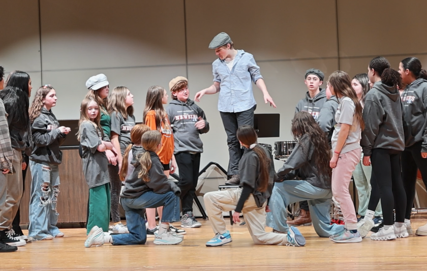 students performing on stage during rehearsal