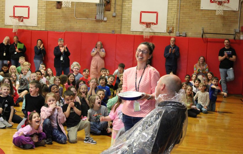 teacher laughs with pie in hand